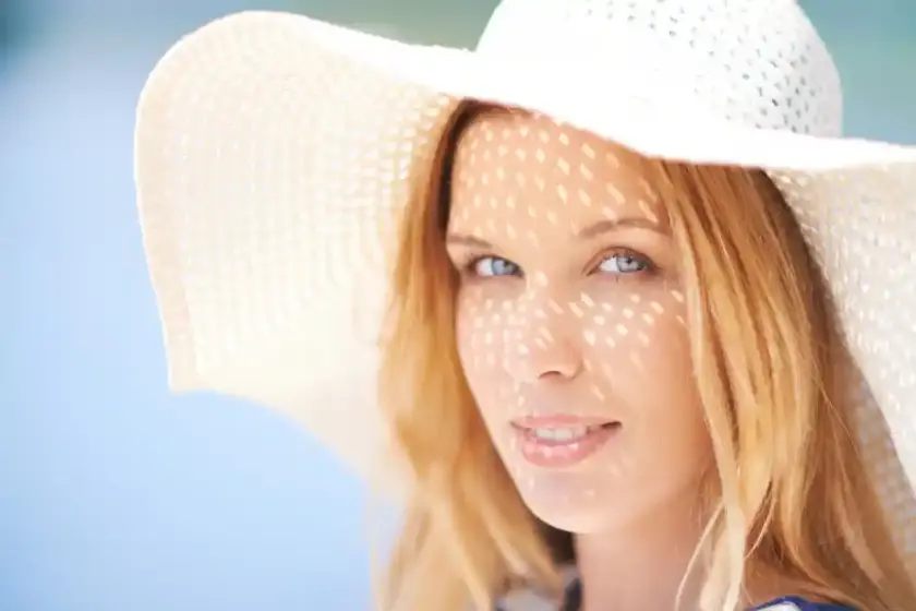Woman with smooth skin wearing a sunhat, symbolizing youthful appearance and results of wrinkle treatments at Berlet Plastic Surgery.